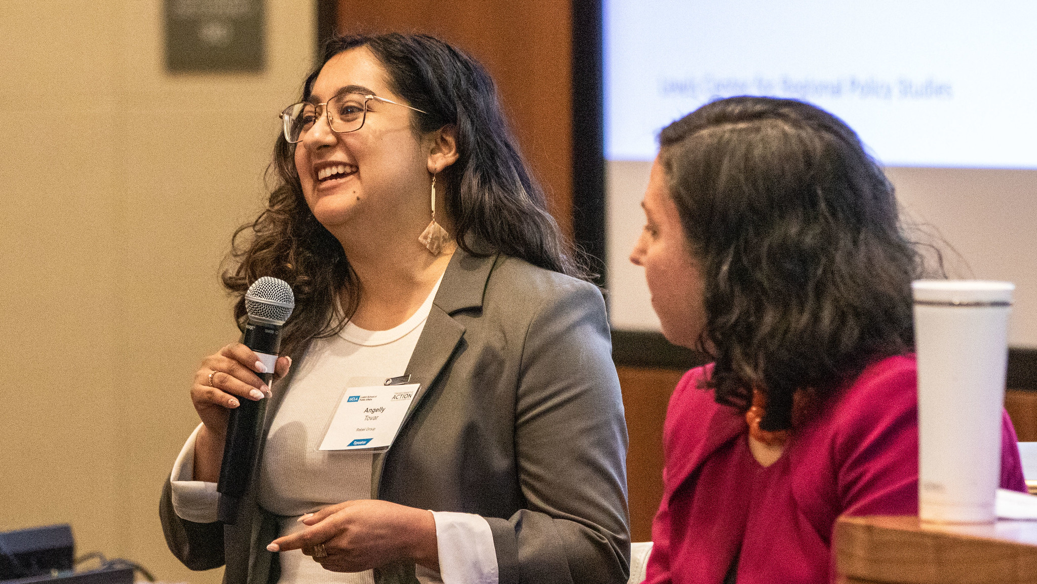 Angelly Tovar (left), holding a microphone, with Avital Shavit seated next to her.